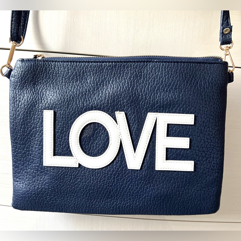 A navy blue shoulder and wristlet, adjustable strap to also wear as a crossbody